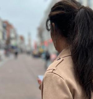 一名女子拿着手机走在街上