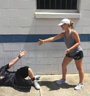 žena ukazuje na muže ležícího na zemi