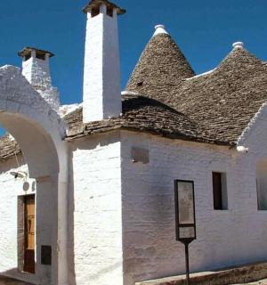 an old white building with a tower and a roof