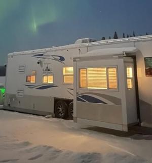 karavan zaparkovaný ve sněhu s otevřenými dveřmi