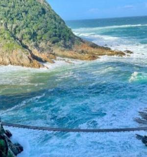 an aerial view of the ocean with a bridge