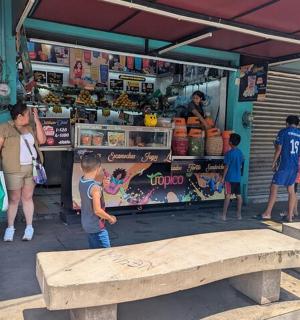 a group of people standing outside of a food stand