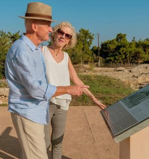 a man and a woman standing next to a sign