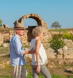 a man and a woman walking in front of a ruins