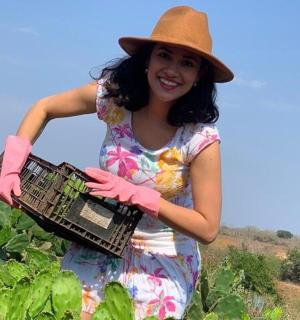 a woman in a hat holding a basket in a field