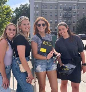 skupina žen stojící vedle plotu