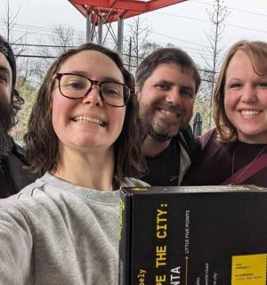 skupina lidí pózujících pro fotografii s knihou