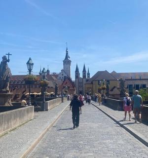 eine Gruppe von Menschen, die auf einer Brücke über einer Stadt spazieren