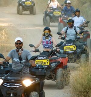 一群人骑着四轮摩托车在土路上行驶