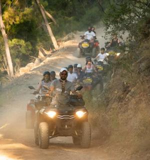 一群人骑着四轮摩托车在土路上行驶