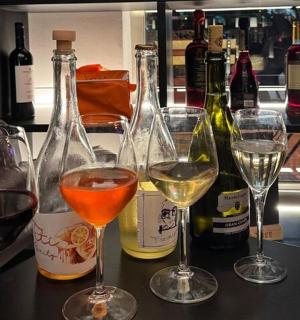 Skupina sklenic na víno na pultu s lahvemi vína