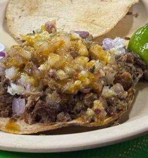 a taco with chili and a lime on a plate