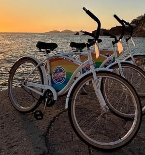 two bikes parked on the beach at sunset