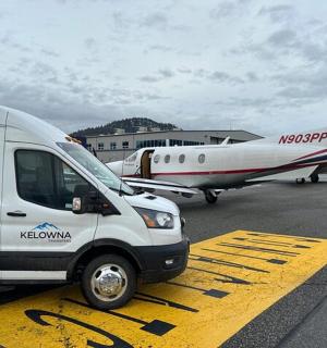 一辆白色货车停在一架小型飞机旁边