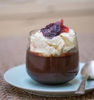 a dessert in a glass on a plate with a spoon