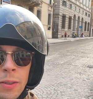 一名戴着头盔的男子在街上骑摩托车