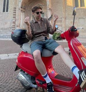 一名男子坐在一辆红色摩托车上