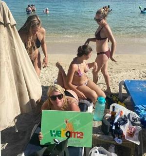 一群穿着泳衣的女人坐在海滩上