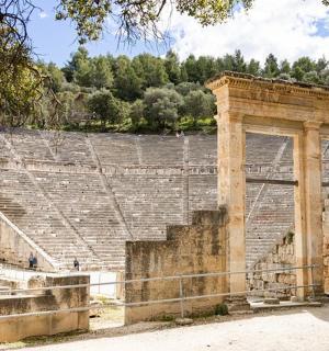 an ancient amphitheatre with a person standing in front