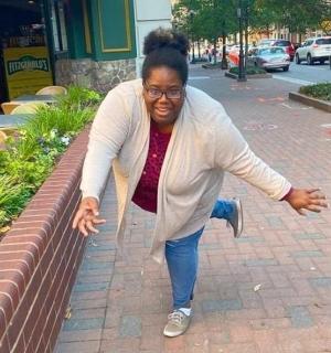 a woman is leaning on a brick wall