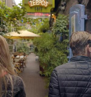 a couple of people walking down a sidewalk