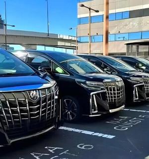 a row of luxury cars parked in a parking lot