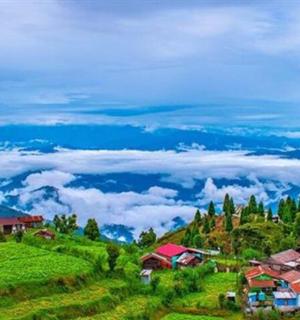 云雾缭绕的绿色山丘上的一组房屋