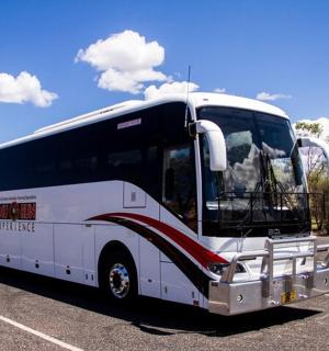 bílý autobus zaparkovaný na parkovišti