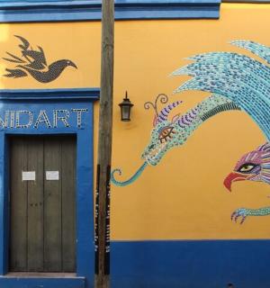 a blue and yellow building with a painting of a dragon
