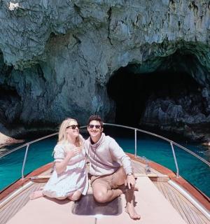 muž a žena sedící na lodi v jeskyni