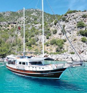 a boat sitting in the water next to a mountain