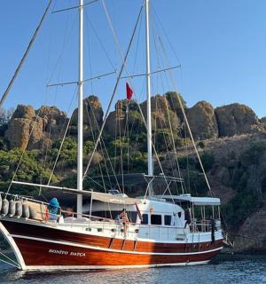 a boat is docked in the water next to a mountain