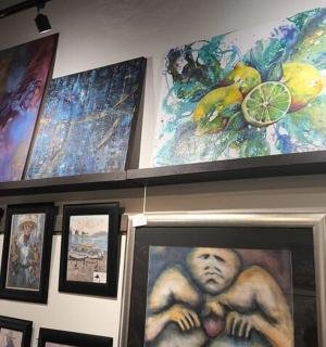 a shelf with paintings and pictures on a wall