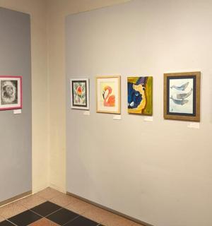 a group of framed pictures on a wall in a museum