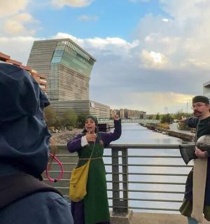 一名女子正在拍摄两名站在河边的男子