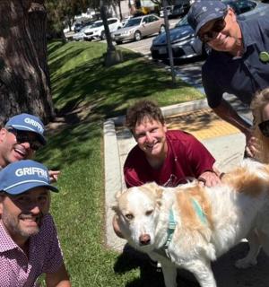 a group of people posing for a picture with a dog