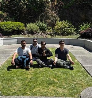 skupina mužů sedících na trávě