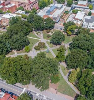 an aerial view of a park with trees in a city