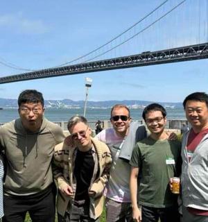 a group of people standing in front of a bridge