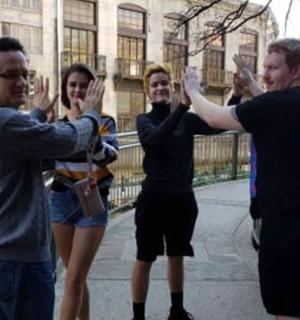 skupina lidí stojící na mostě se zdviženýma rukama