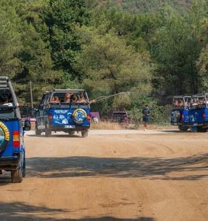 两辆蓝色巴士沿着土路行驶