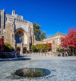 a church with a reflection of a fountain in front of it