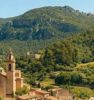 a small town with a church in front of a mountain