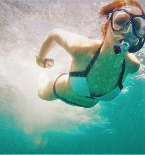 a woman in a swimsuit and glasses in the water