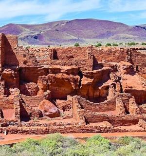 an ancient building in the desert with mountains in the background