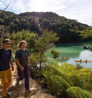 两个人站在山上俯瞰一片水域