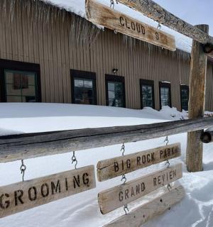 a wooden fence in the snow in front of a building