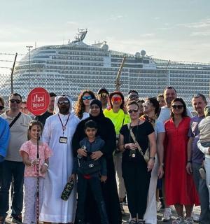 skupina lidí stojících před výletní lodí