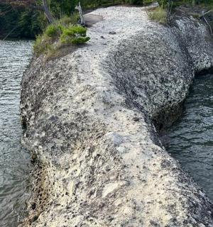 a large rock in the middle of a body of water