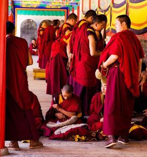 skupina mnichů stojících ve skupině v klášteře